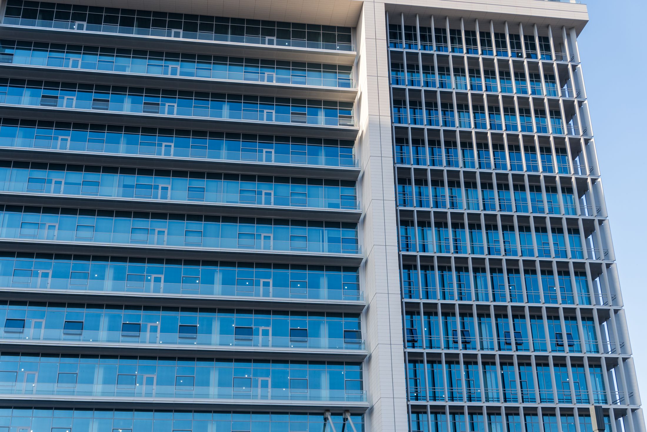The glass facade of a modern office building, used as an illustrative image