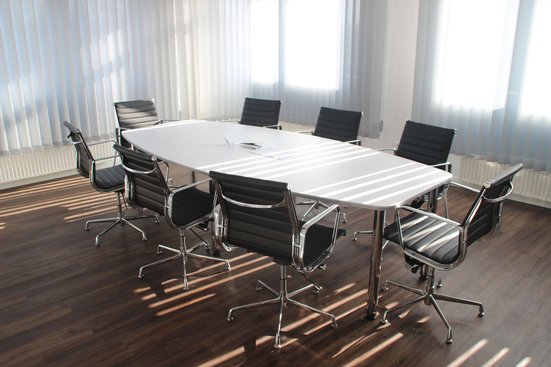 An empty boardroom with a meeting table and chairs, used as an illustrative business image