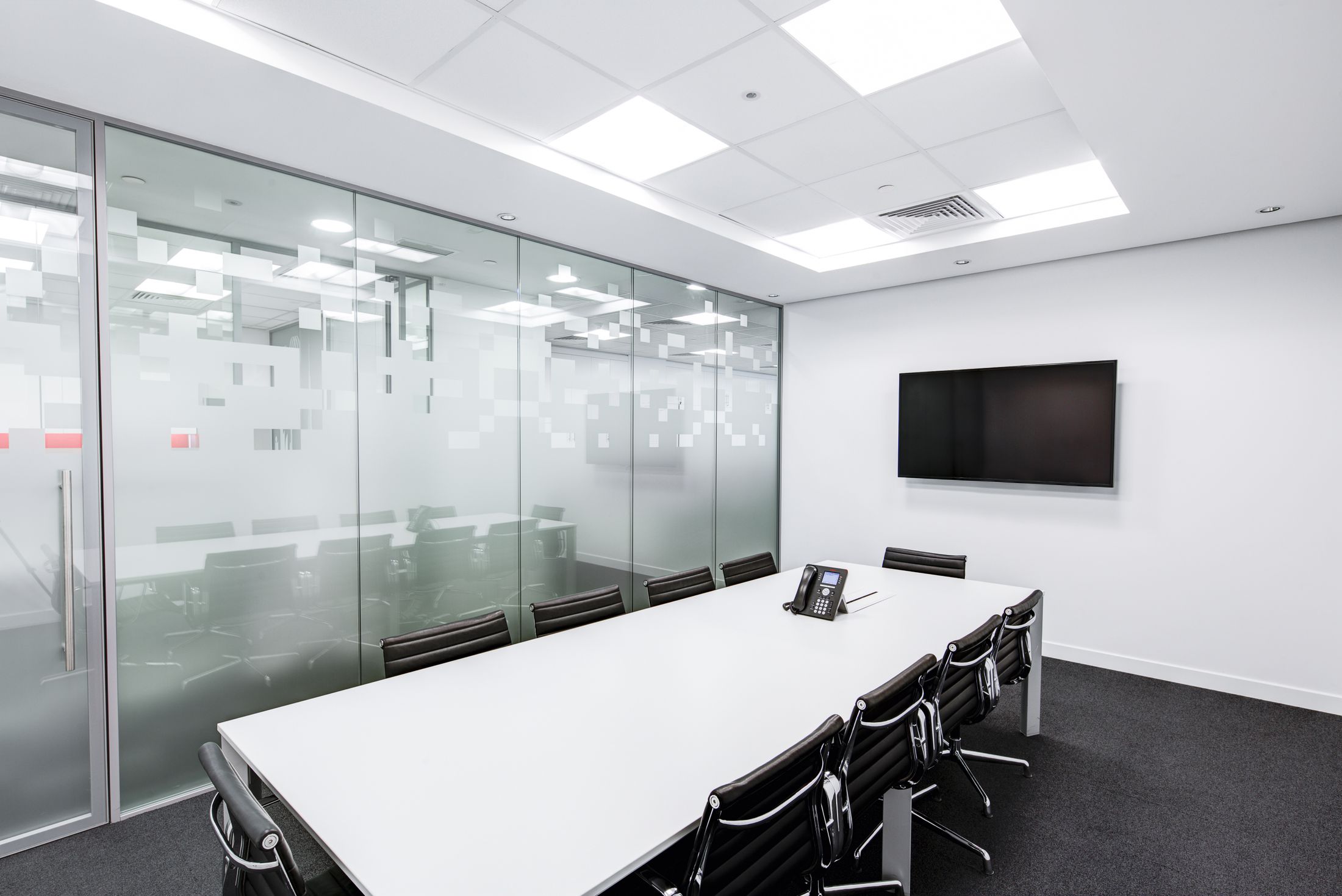 An empty glass-walled meeting room, used as an illustrative business image